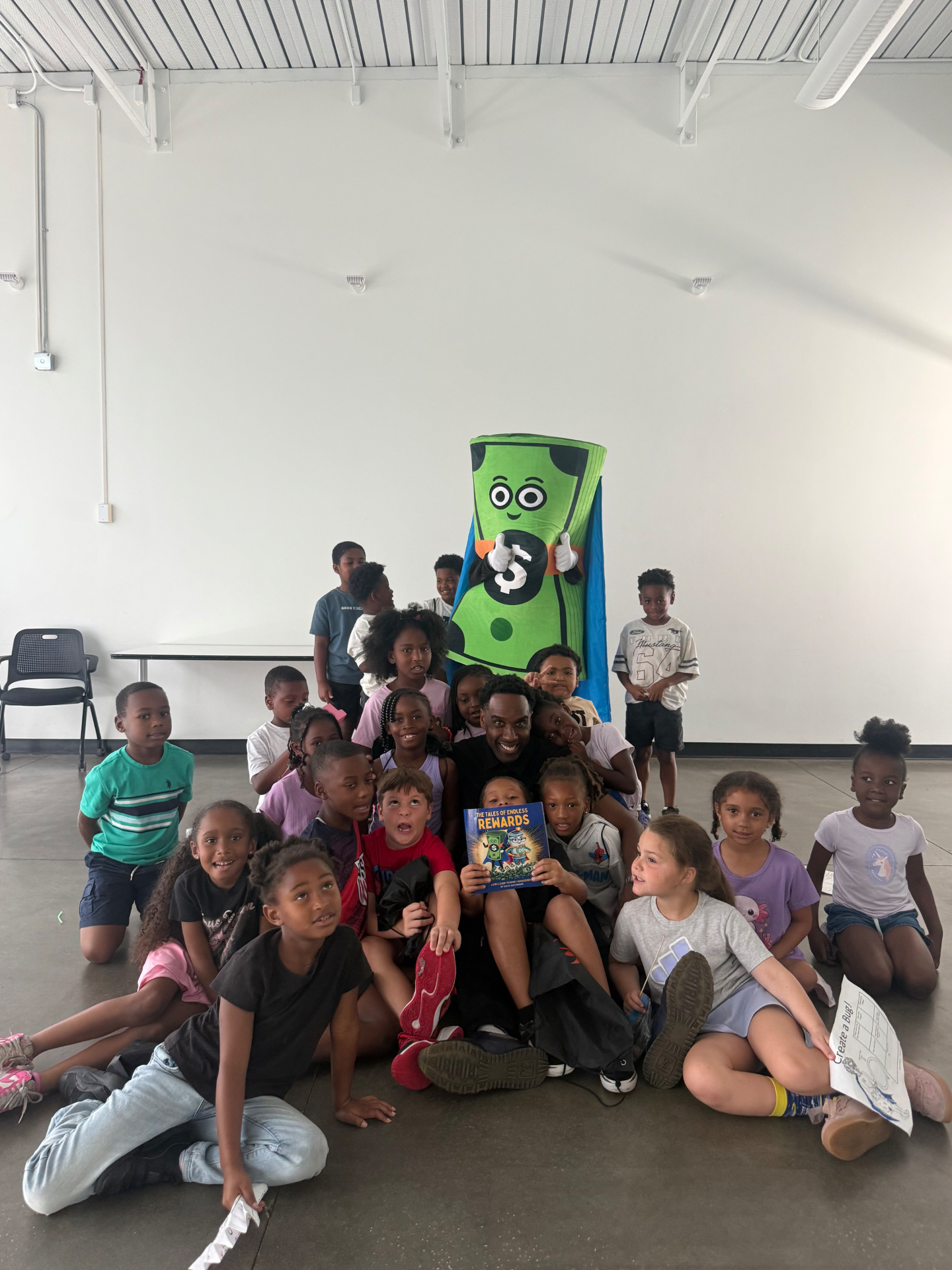 Dave Alexandre and Captain Cash with a group of young readers holding the book